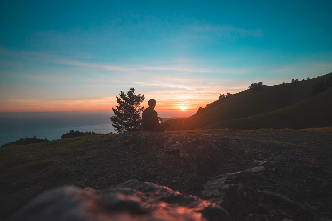 person meditating at sunrise