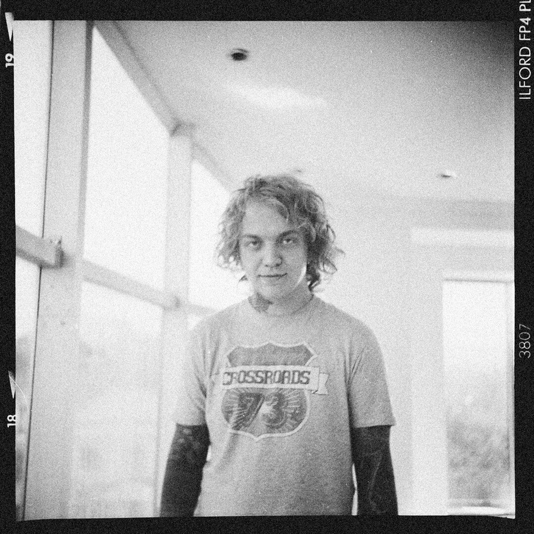 Portrait of a young Latin American musician holding a guitar backstage