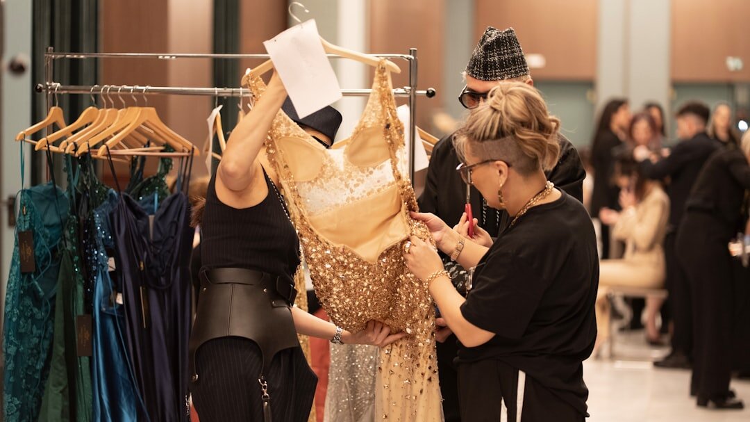 Backstage crew adjusting a model's dress before a runway show at BAFWEEK